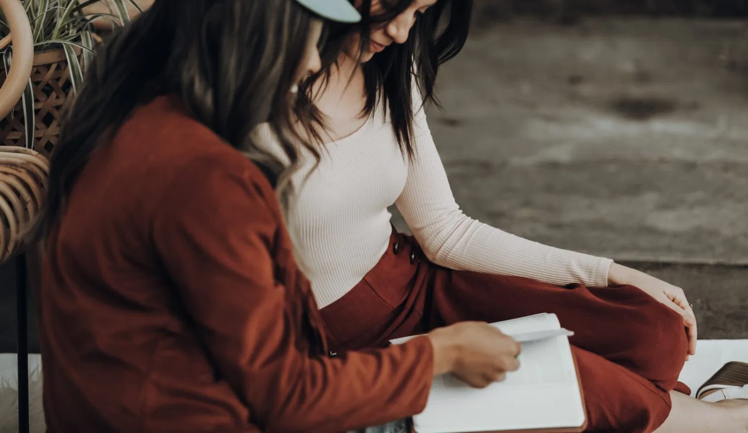 woman in white tank top and orange jacket holding white printer paper