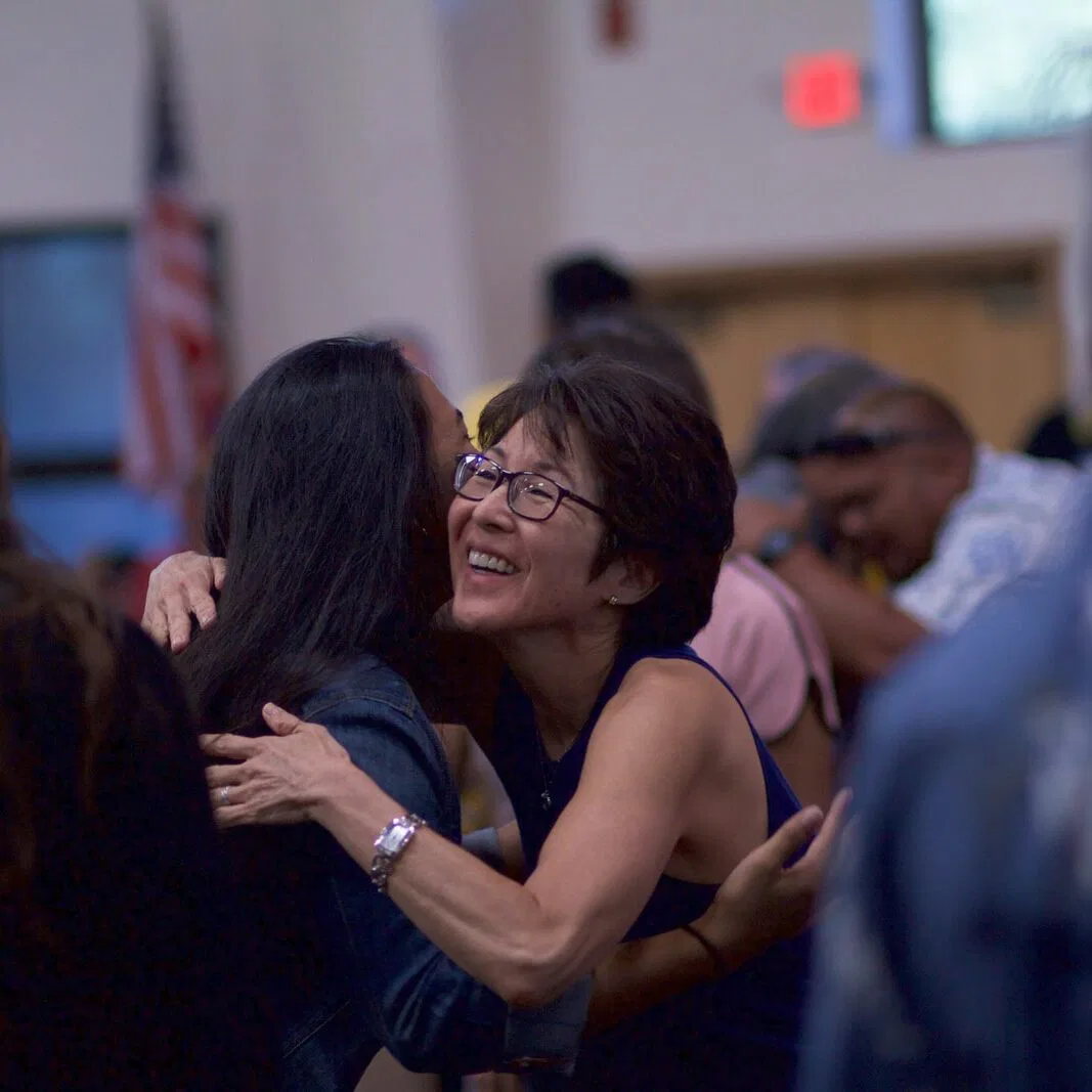 selective focus photography of two women hugging