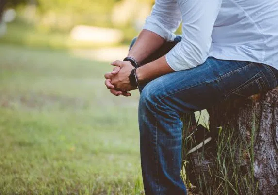 man wearing long sleeved shirt sitting