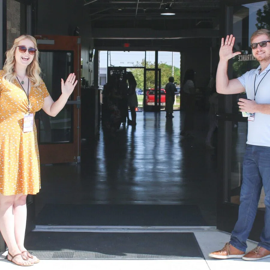two man and woman standing on doorway